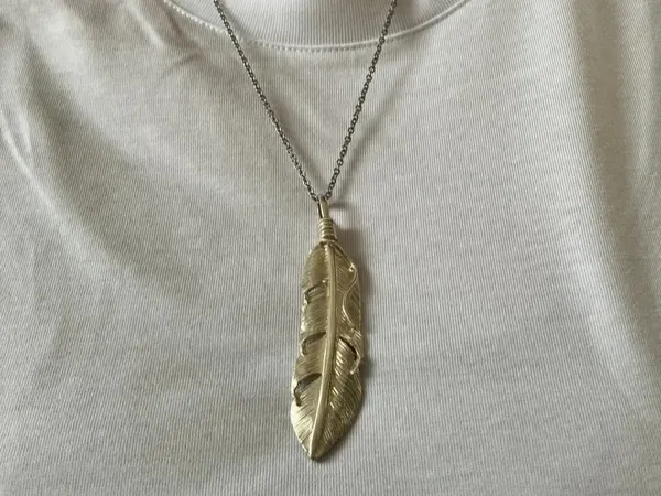 フェザーのペンダントをしたの画像
